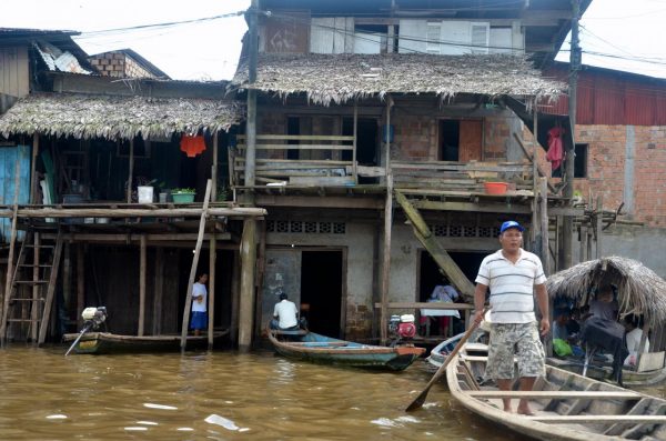 A man stands in a canoe in Iquitos, Peru